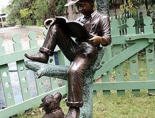 Reading boy mailbox sculpture