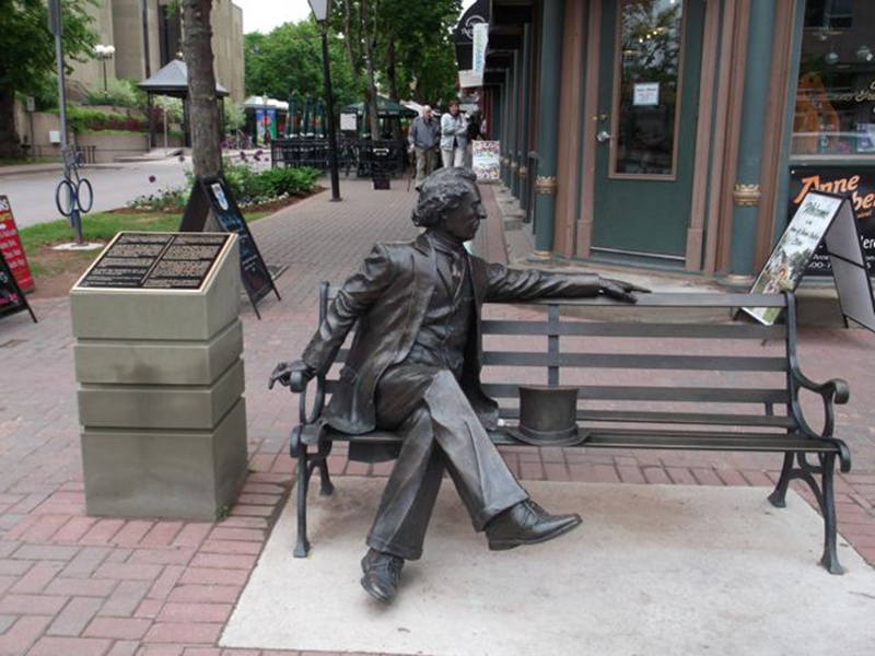 man sitting on bench sculpture
